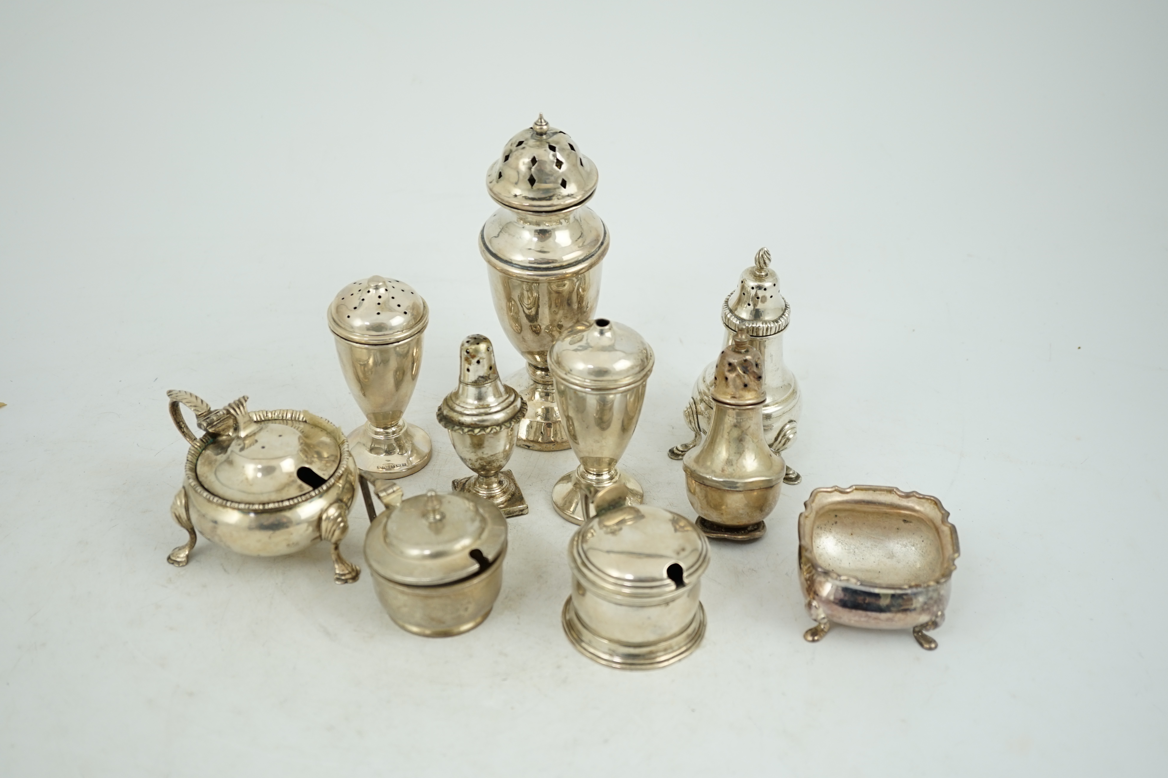 Nine assorted early 20th century and later silver condiments, various dates and makers and one plated condiment.